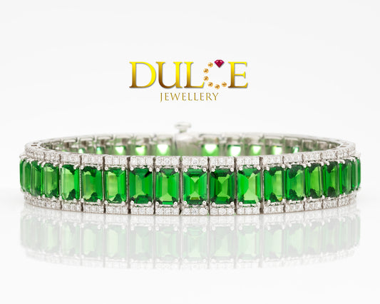 Elegant bracelet featuring emerald-shaped tsavorite gemstones, accented with shimmering diamonds, showcasing a refined and luxurious design.