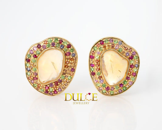 "Fire opal centerpiece surrounded by a halo of vibrant multi-color gemstones in a delicate gold setting."